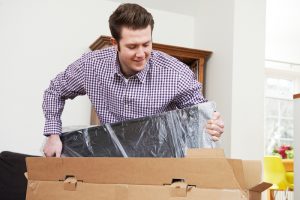 Post Falls Idaho man packing tv safely in a tv box is the best way to store a tv for moving and self storage moving boxes