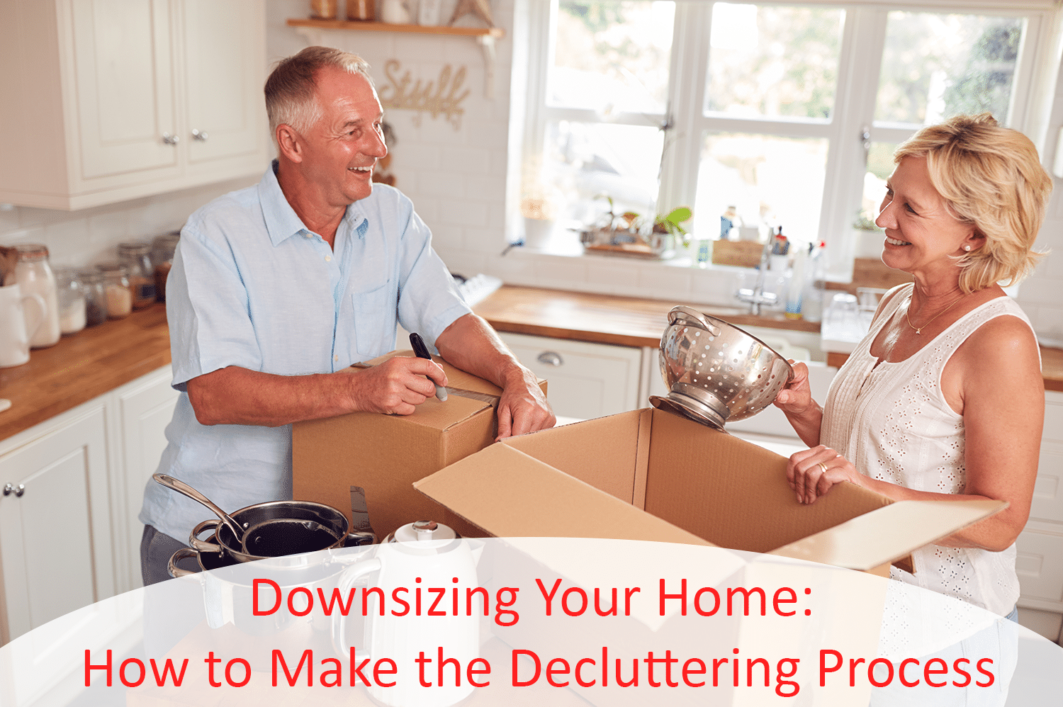 An elderly couple downsizing their home by putting kitchen items into boxes.